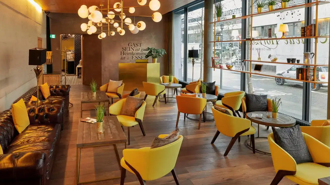 Modernes Cafe mit gelben Stühlen, Holztischen, großen Fenstern und dekorativer Beleuchtung.